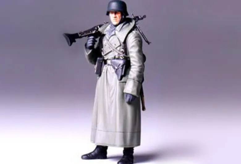 Tamiya 36306WWII Figur Deutscher Soldat mit Mantel und MG, Bausatz, 1:16